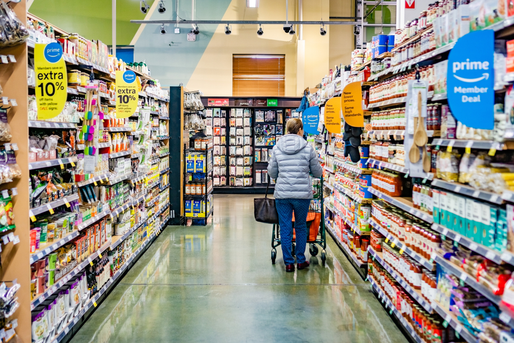Women pushing a shopping trolley down Amazon Fresh aisle