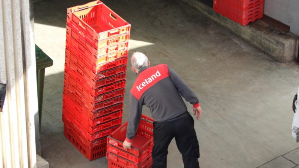 Iceland worker stacking delivery crates