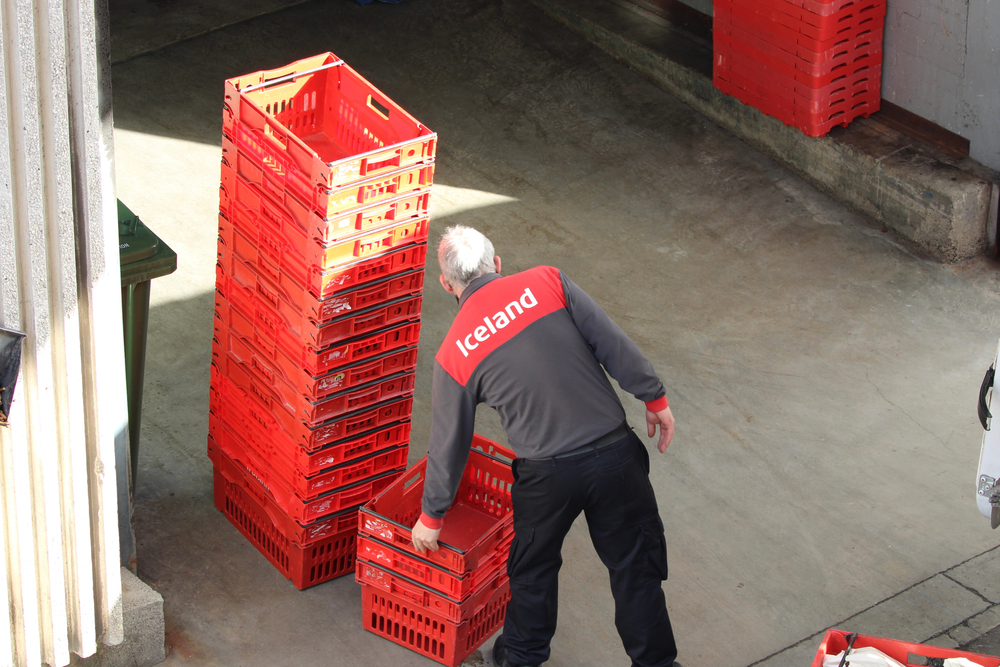 Iceland worker stacking delivery crates