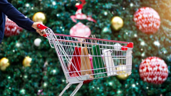 Shopping trolley full of bags in front of Christmas tree