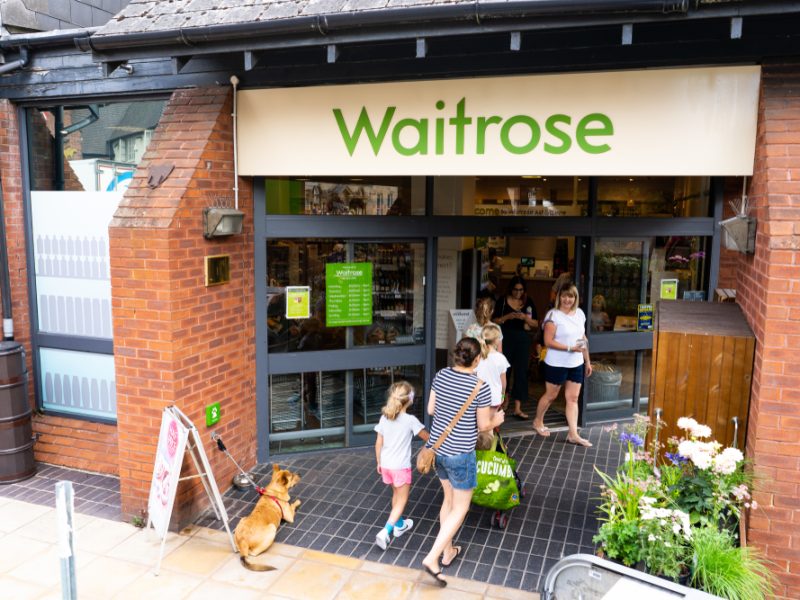 Customers coming in and out of a Waitrose store