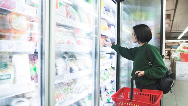 A shopper browses the frozen foods section in a supermarket.