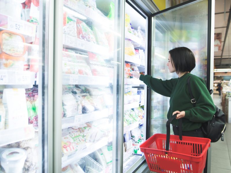 A shopper browses the frozen foods section in a supermarket.