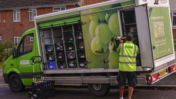 Asda worker loads products into a delivery van