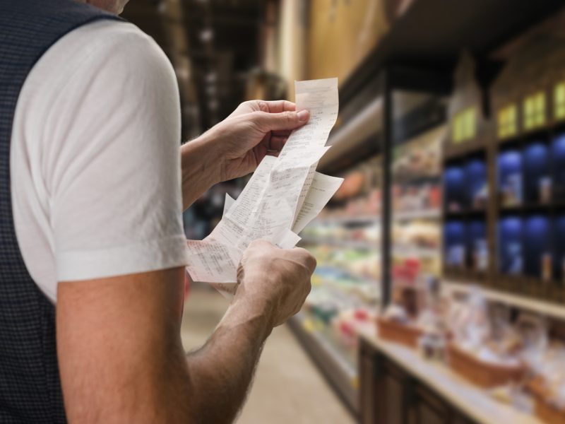 Close up of customer looking at recent, noticing food inflation