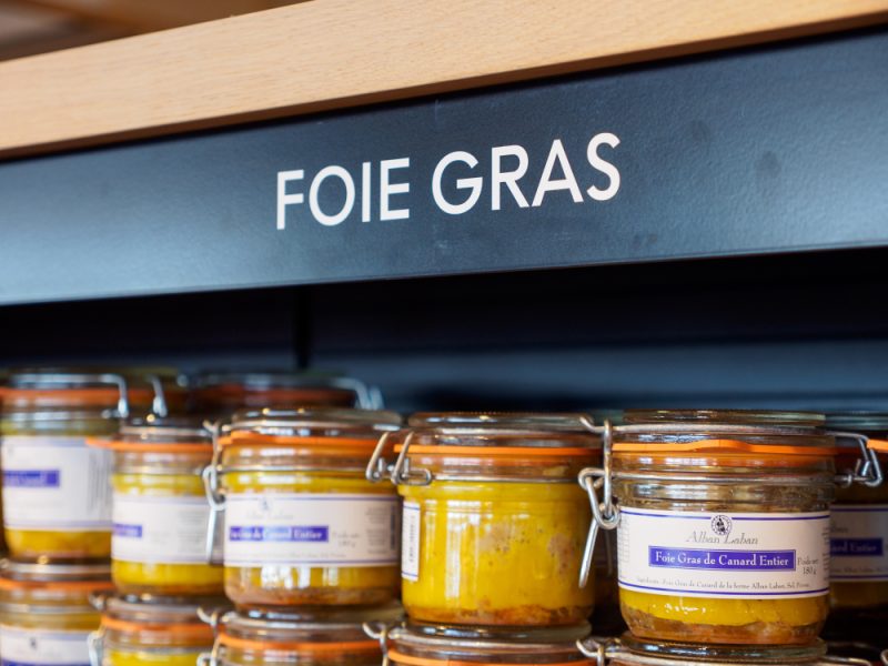 Jars of foie gras sit on a supermarket shelf.