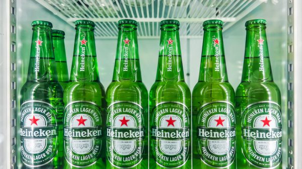 A row of Heineken beer bottles in a supermarket.