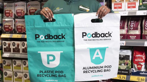 A Morrisons employee holds up two Podback bags.