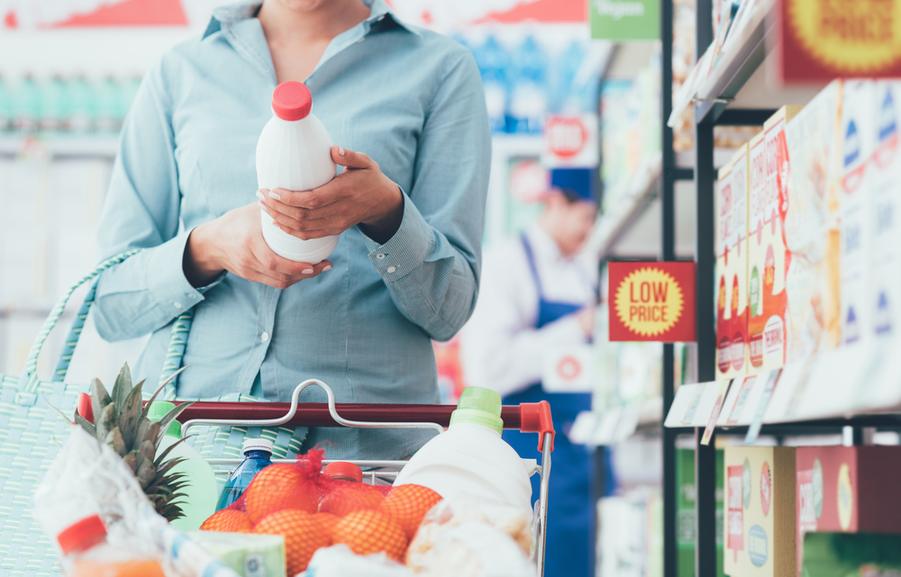 Customer looking at best before date on milk carton