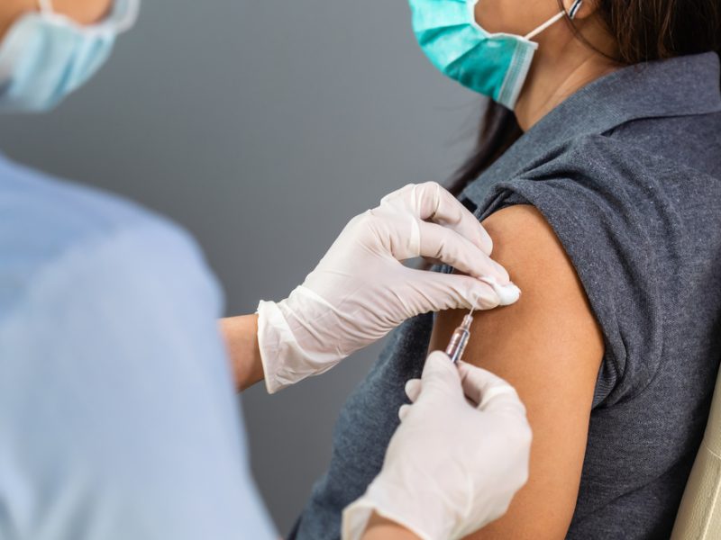 A healthcare worker administering a Covid-19 vaccine