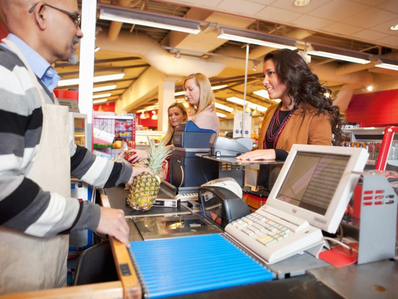 Grocery shopper at checkout purchasing food