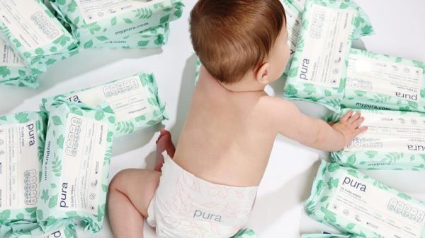 Baby surrounded by Pura baby wipes