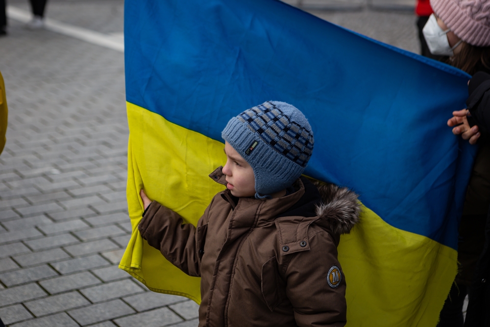 A child holds a Ukraine flag.