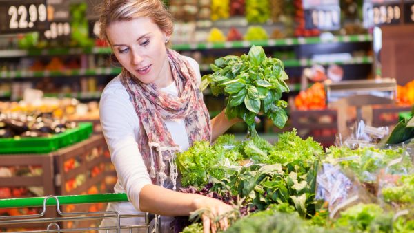 Customer looking at fresh fruit and veg in supermarket