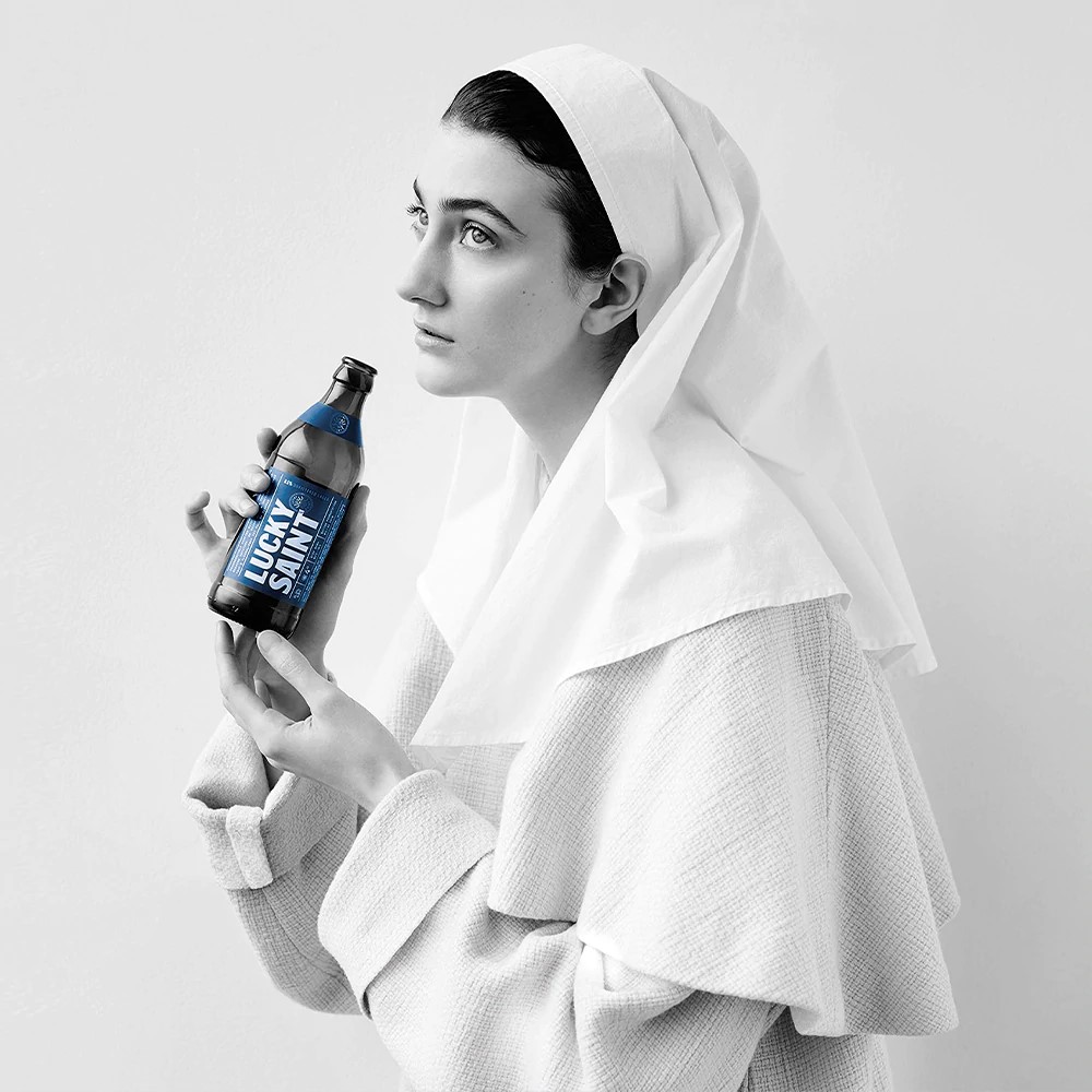Lady sitting with a lucky saint beer