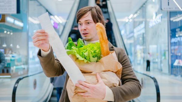 customer looking surprised at receipt after doing a grocery shop