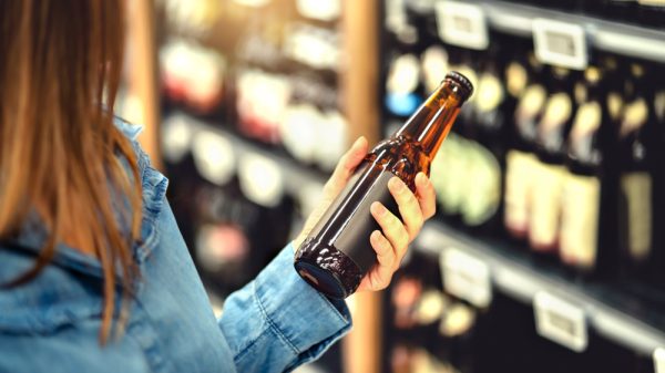 Customer looking at non-alcoholic beer in supermarket