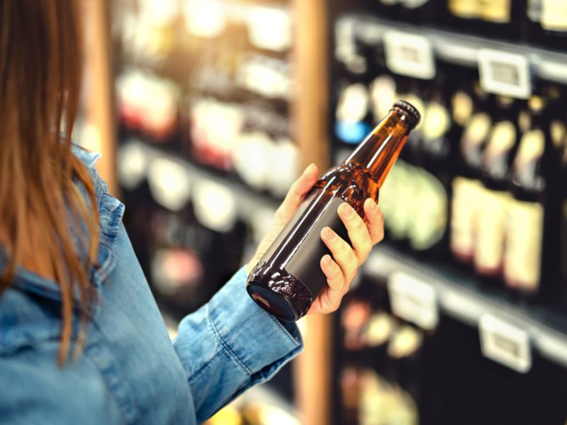Customer looking at non-alcoholic beer in supermarket