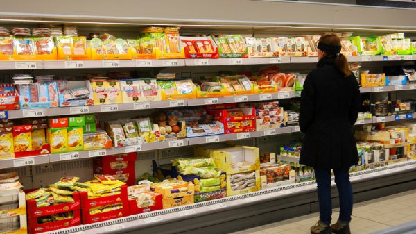 A shopper browses the chilled section in a supermarket.