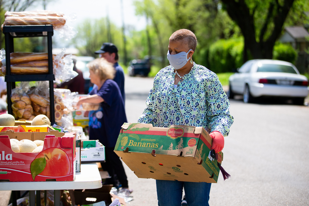 A person carries bananas into a food bank.