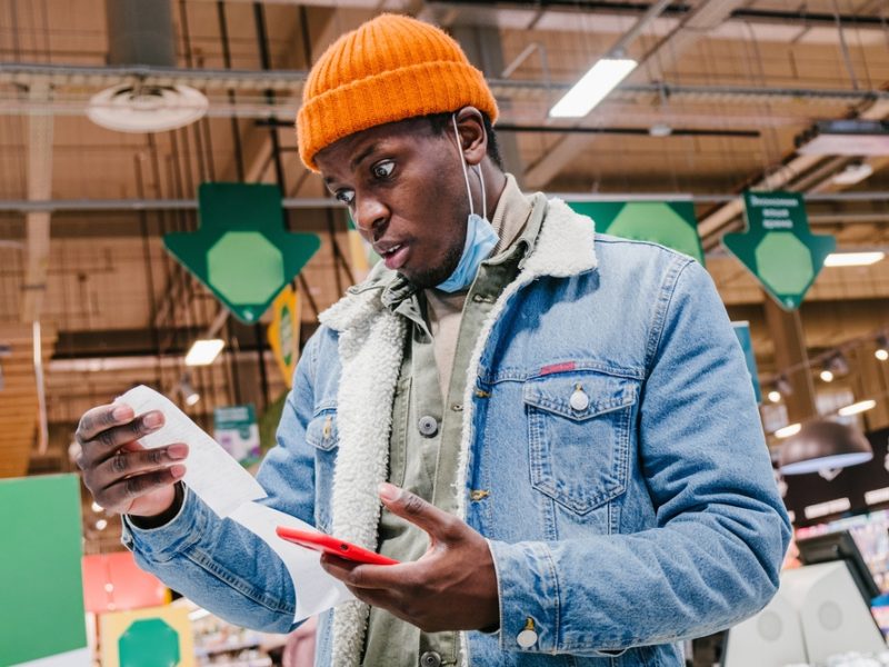 customer reading supermarket bill after purchasing goods