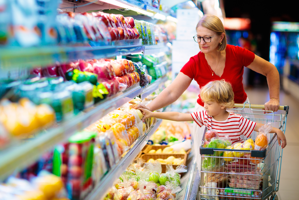 A mother and son browsing healthy produce in a supermarket.