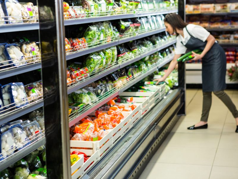 Supermarket worker stocking shelves.