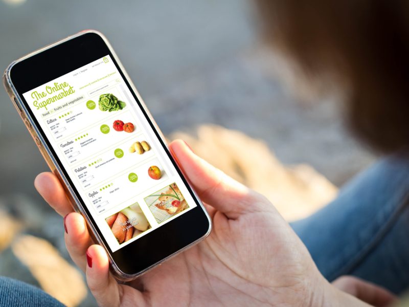 Customer looking at a phone to purchase items from online supermarket