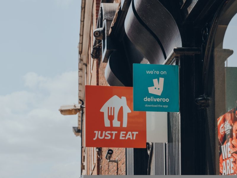 Deliveroo and Just Eat signs - re rapid grocery delivery dervices