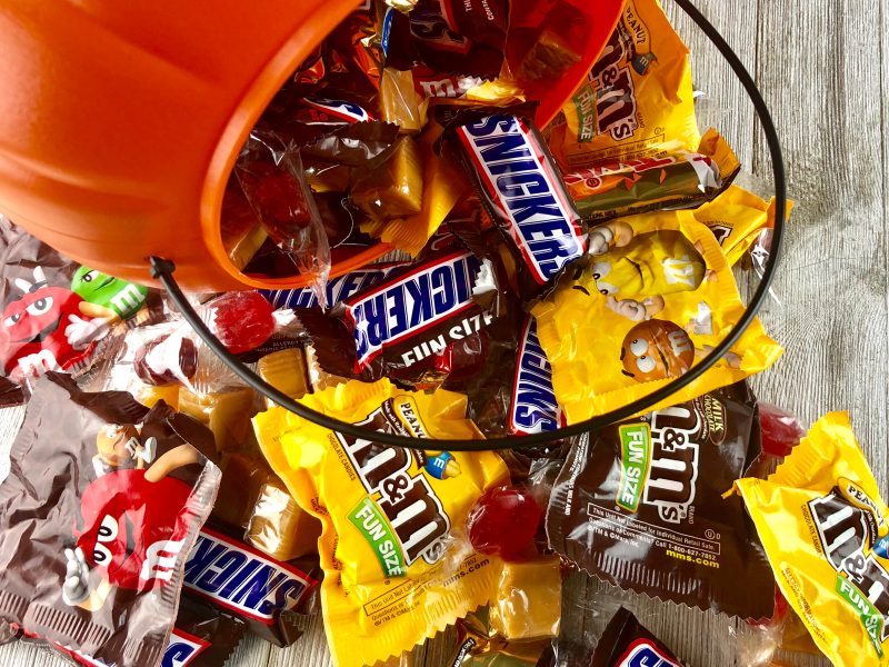 Halloween sweet sales have fallen 5% compared to last year, following British consumers facing rising costs and subsequently cutting back on the treats, here depicting Halloween candy, sweets and chocolates tumbling out of a pumpkin plastic bucket