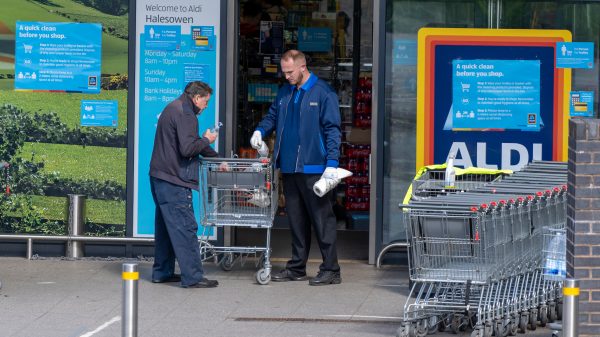 Aldi has become the first supermarket to pay all its store and warehouse colleagues a minimum of £12 an hour nationally, here depicting and Aldi worker with a customer