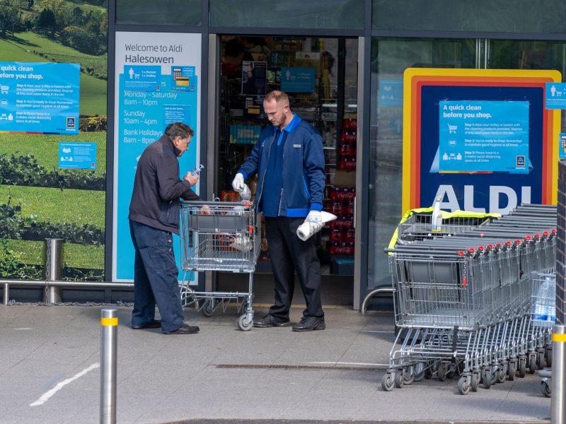 Aldi has become the first supermarket to pay all its store and warehouse colleagues a minimum of £12 an hour nationally, here depicting and Aldi worker with a customer