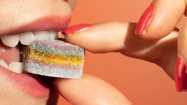 Co-op has agreed to a deal with nutritional gummy brand Nourished, to see the 3D-printed sweets hit the retailer's shelves, here depicting a woman placing a sweet into her mouth