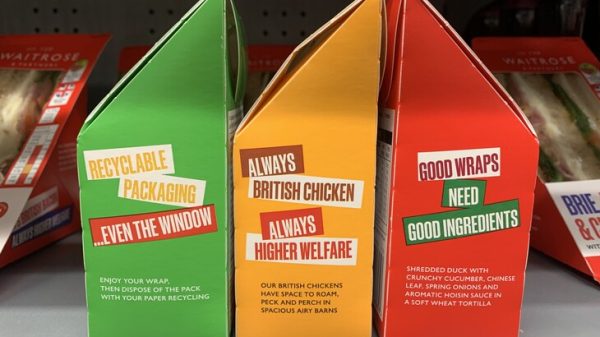 Here showing a relaunched Food To Go range from Waitrose, including new sustainable packaging that is championing British ingredients and animal welfare. The packages are green, orange and red with writing on it.