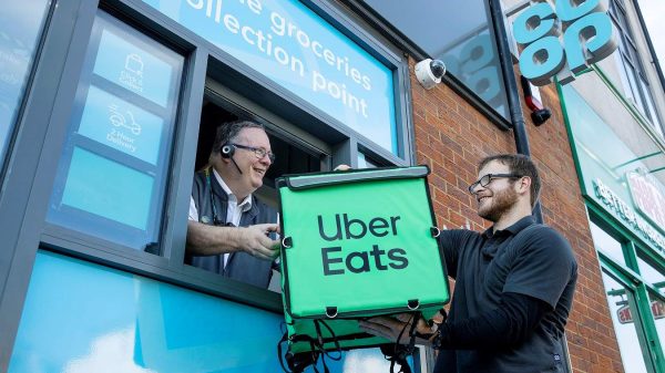 Here depicting an Uber Eat driver passing a branded delivery bag to a Co-op staff member